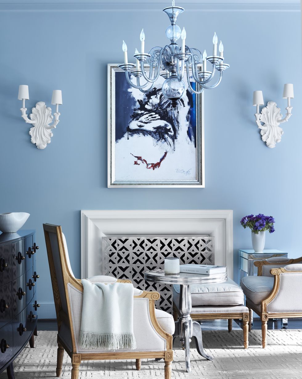 Elegant living room with a blue lime-based painted wall, ornate chandelier, and sophisticated French-style furniture.
