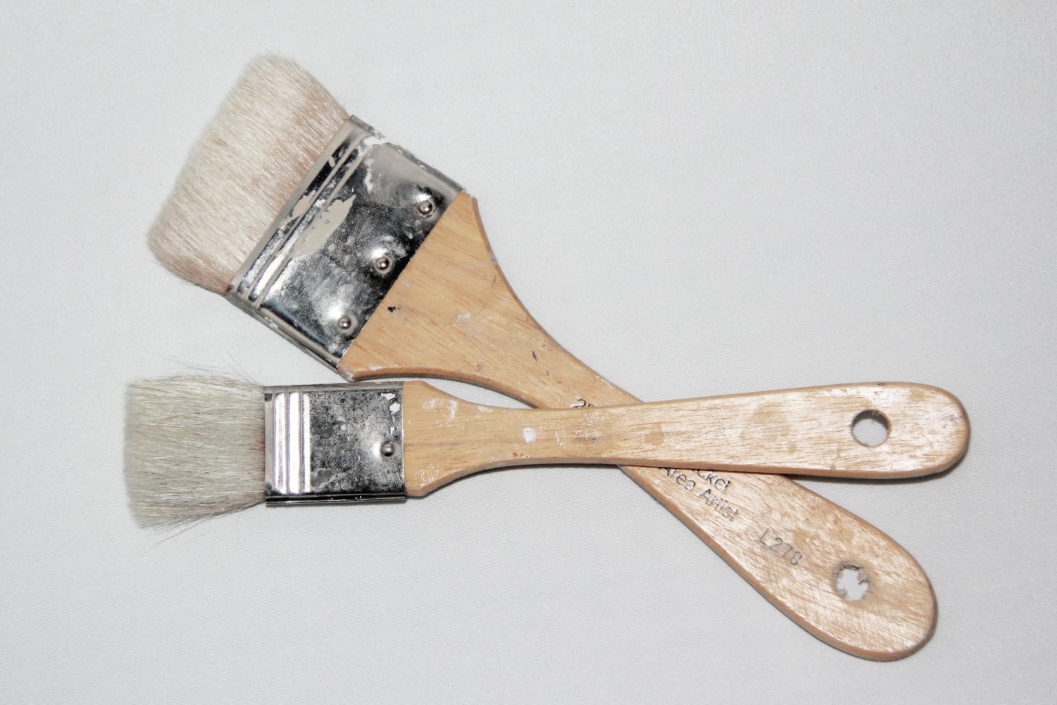 Two Paintbrushes with Wooden Handles on White Background
