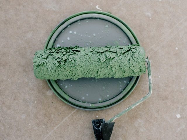 Old Paint Roller with Dried Green Paint Over an Open Paint Can