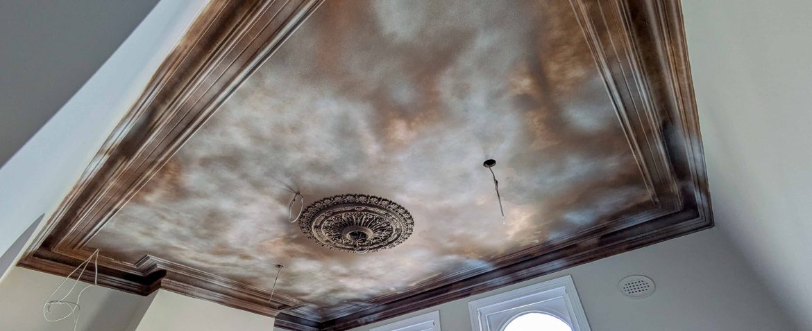 Ornate ceiling design with vintage detailing and intricate moldings in a room.