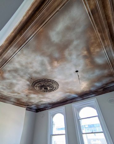 Ornate ceiling design with vintage detailing and intricate moldings in a room.
