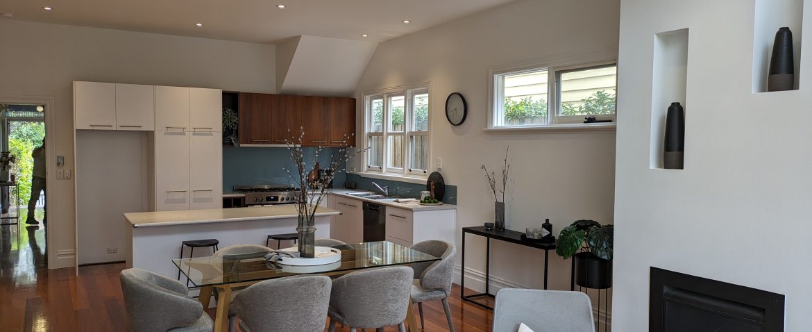 Modern kitchen and dining room with sleek design, wooden flooring, and contemporary furniture.