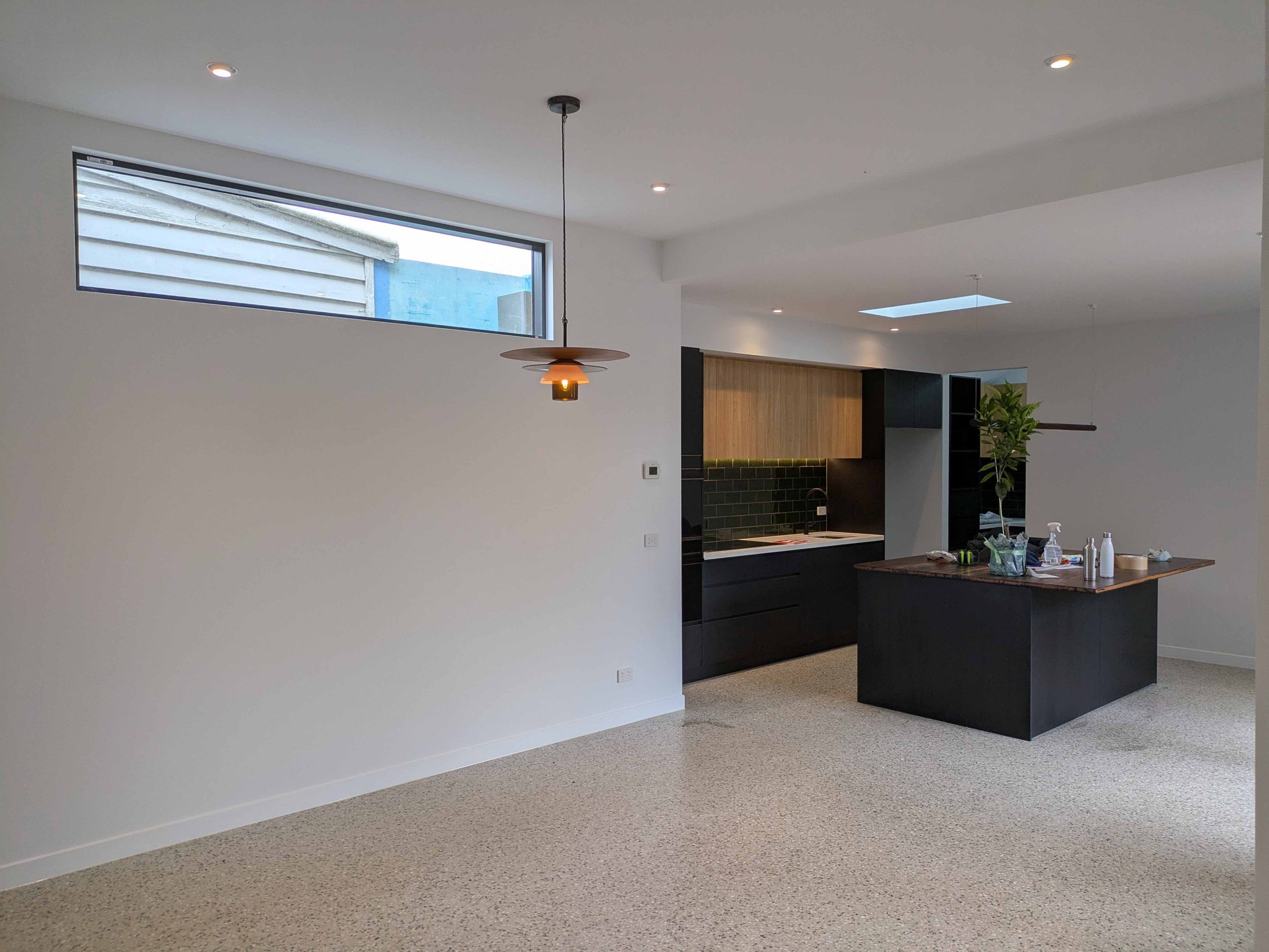 Modern Open-Plan Kitchen and Living Area with Sleek Black and Wood Finishes