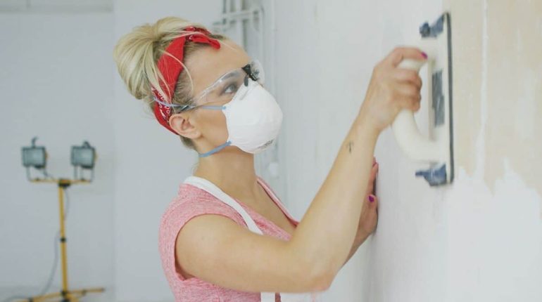 Woman Prepping Wall by Sanding for Smooth Paint Application