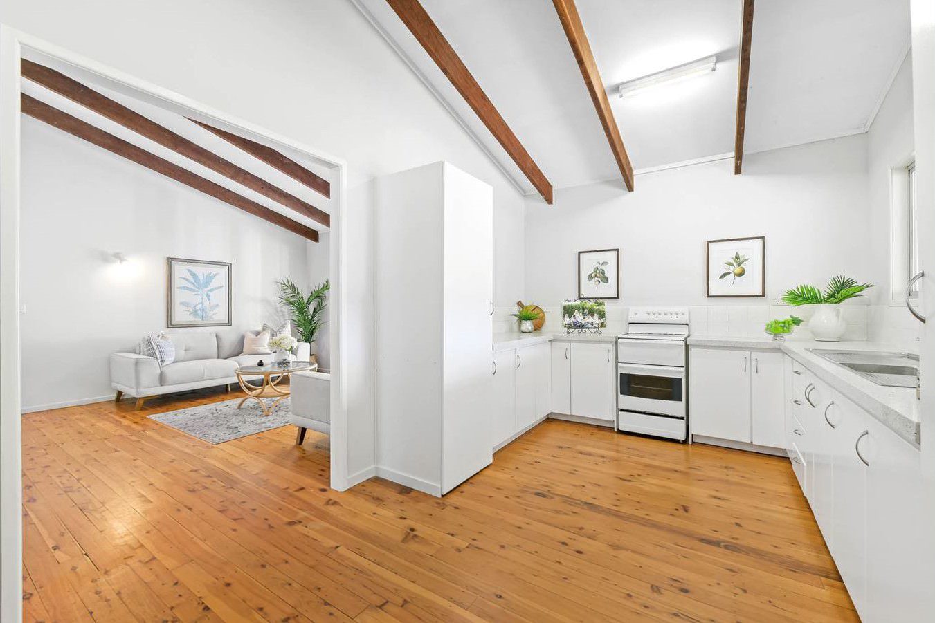 Bright Kitchen and Living Area With White Walls and Exposed Wooden Beams