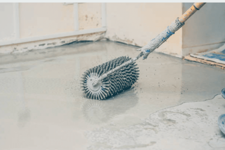 A spiked roller being used on a freshly poured self-leveling floor.