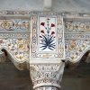 Intricate marble column with floral inlay designs in traditional architectural style.