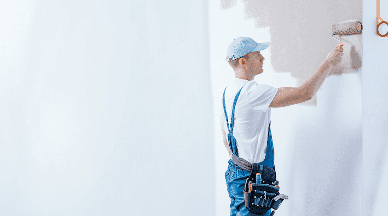 Professional Painter Applying Fresh Coat of Paint to Wall