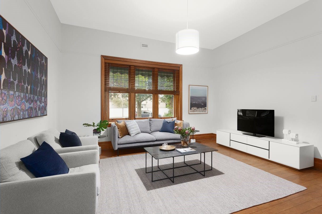 Modern living room with freshly painted white walls, stylish furniture, and wooden accents.