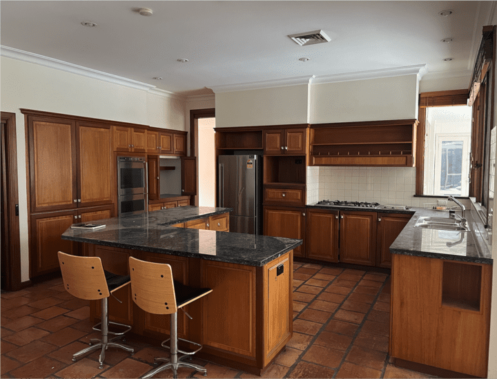 Spacious kitchen with wooden cabinets, granite countertops, and a central island.
