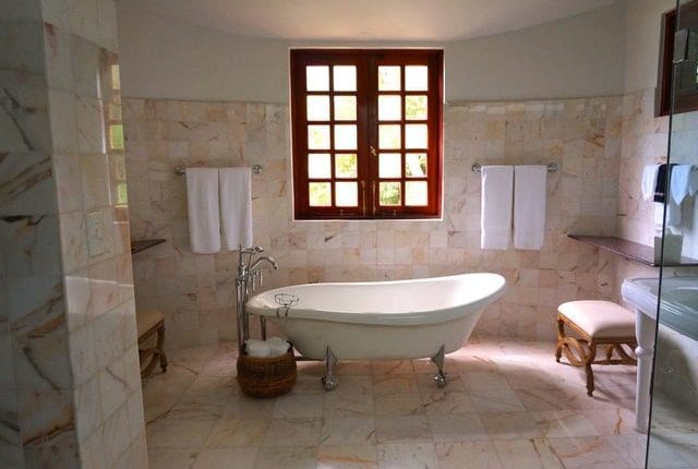 Luxury bathroom with a freestanding bathtub, marble tiles, and elegant décor.