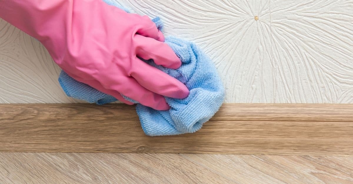 gloved-hand-wiping-wall-with-cloth