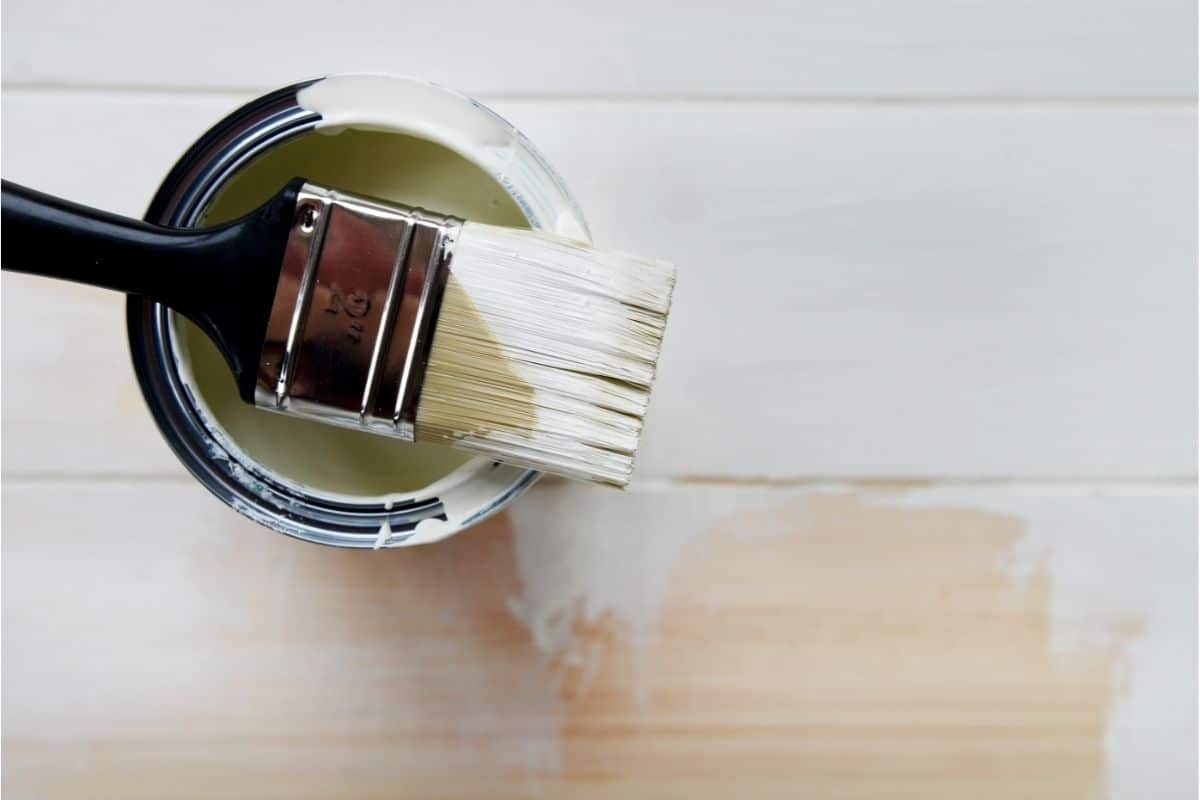 paint brush resting on paint can