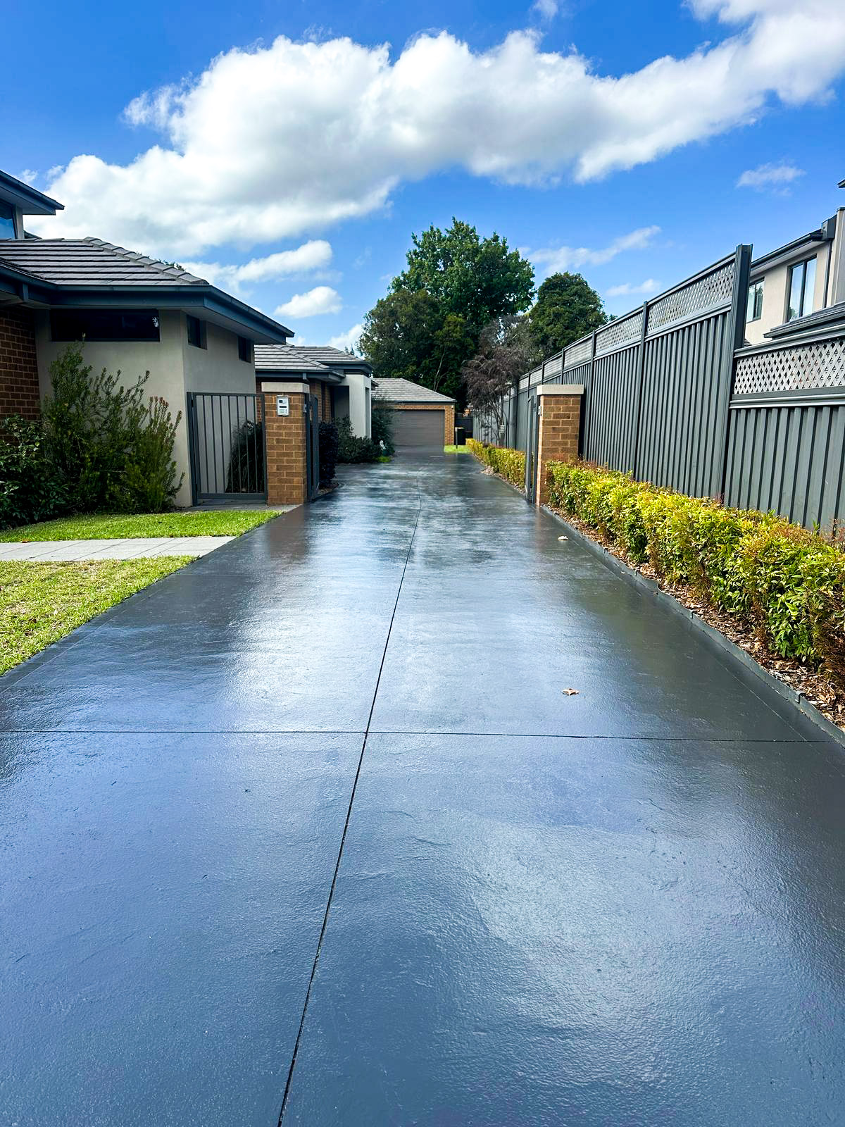 Freshly painted gray driveway with slip-resistant coating in modern residential setting